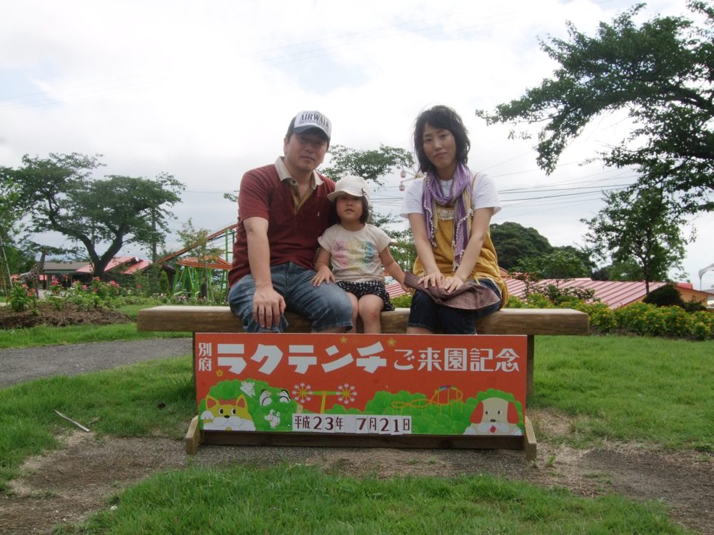 看板の前の家族